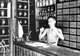 Vietnam: Weighing out medicinal products in a Chinese medicine shop, Hoi An (1950)